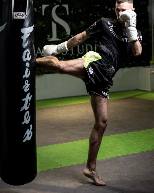 Maksym Chumak — muay thai high kick on a Fairtex heavy bag at Troyan Studio Kraków